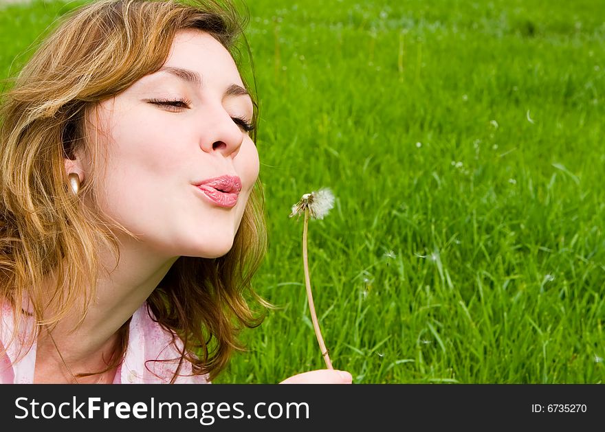 Girl blowing on the dandelion