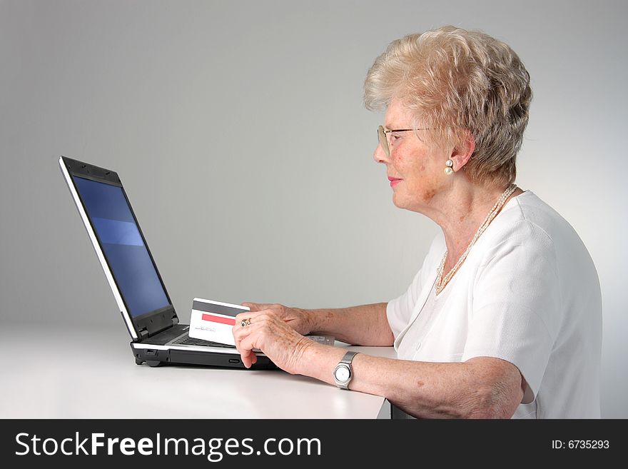 Senior woman with laptop and credit card