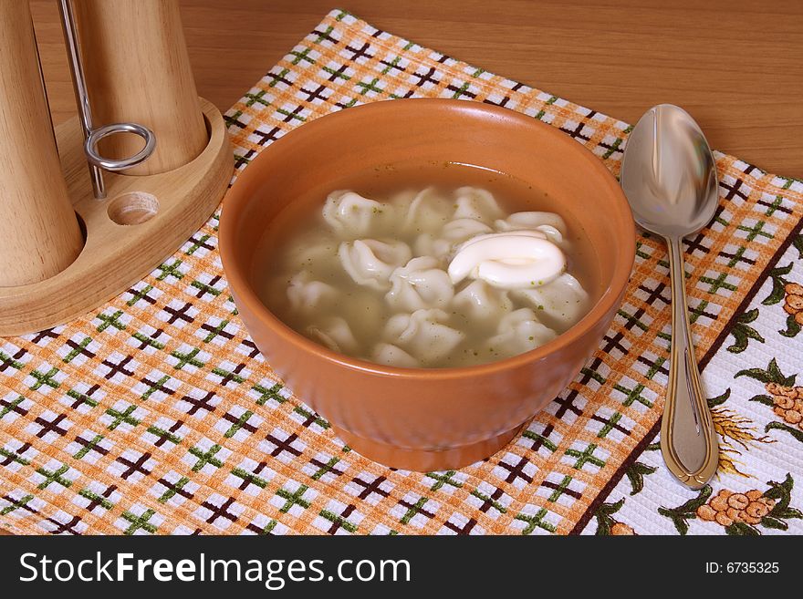 Pel'menis with a broth in a ceramic cup. Pel'menis with a broth in a ceramic cup