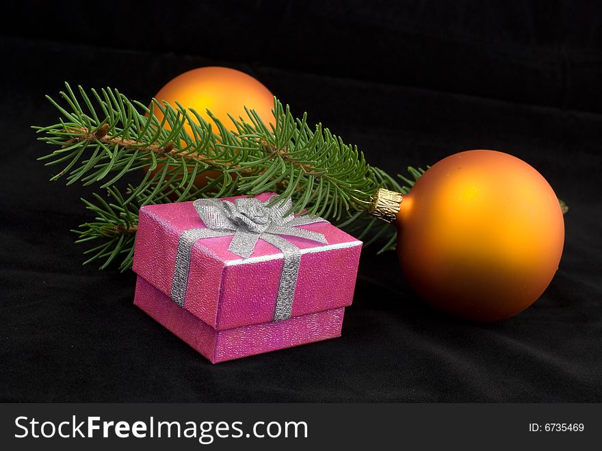 Two yelow christmas balls with present on the black background