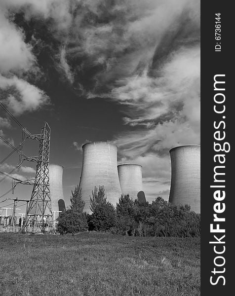 The cooling towers of a power station against a blue sky. The cooling towers of a power station against a blue sky