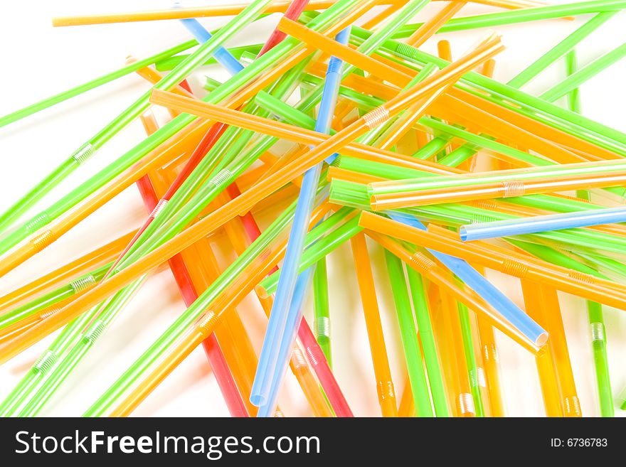 Bunch of multicolored straws on white ground