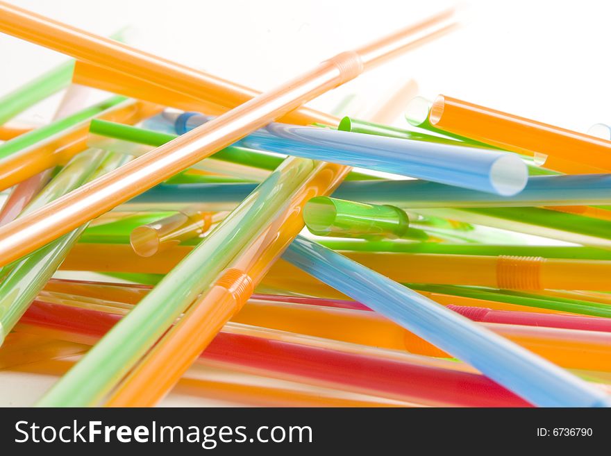 Bunch of multicolored straws on white ground