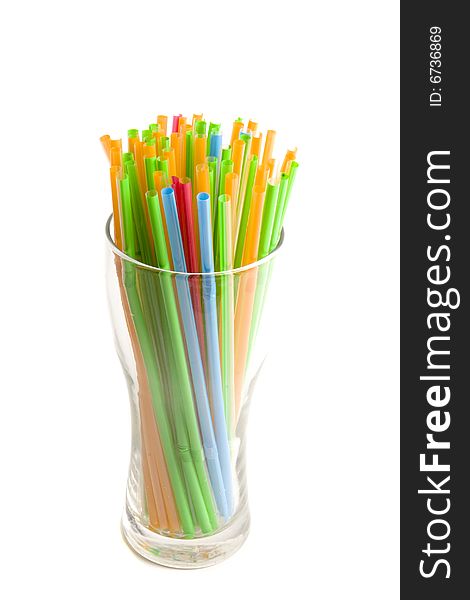 Multicolored straws in glass on white ground