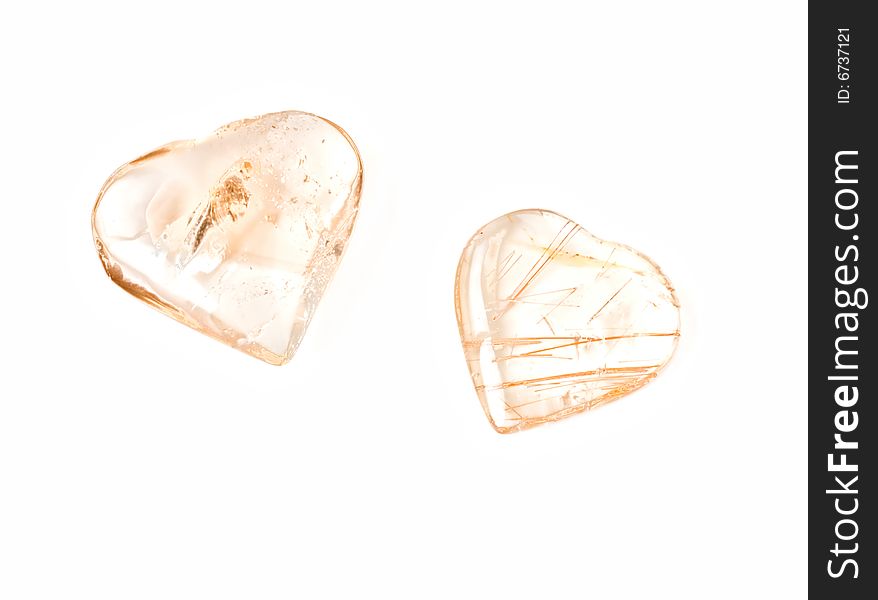 Two heart-shaped crystal stones on white background.