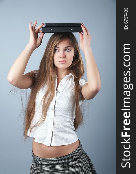 Young student girl woman with a textbook over her head. Young student girl woman with a textbook over her head