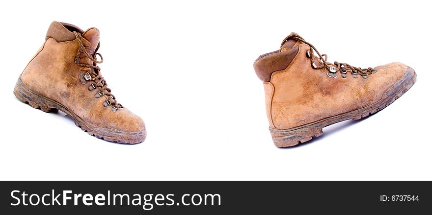 A pair of old worn walking boots isolated on a white background