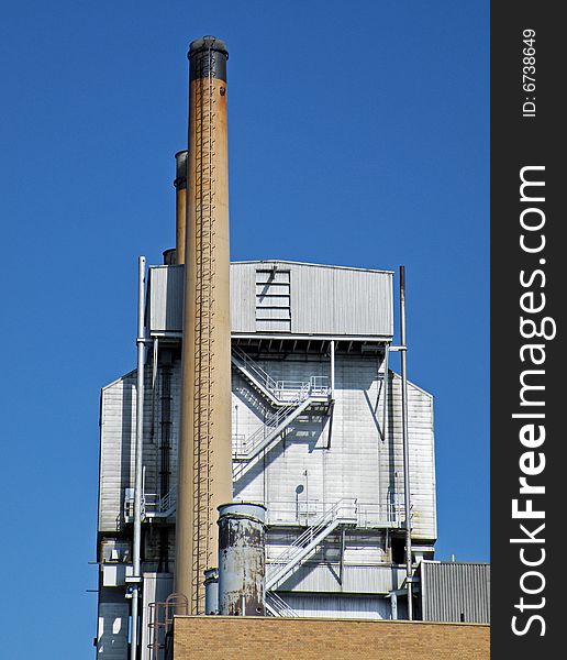 Industrial smokestack against a summer blue sky. Industrial smokestack against a summer blue sky.
