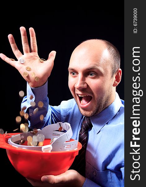 Man in a shirt and a tie fills coins, on a black background. Man in a shirt and a tie fills coins, on a black background