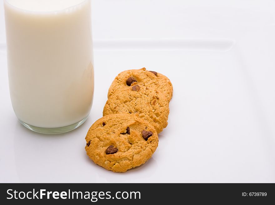 A glass of milk and cookies on a plate