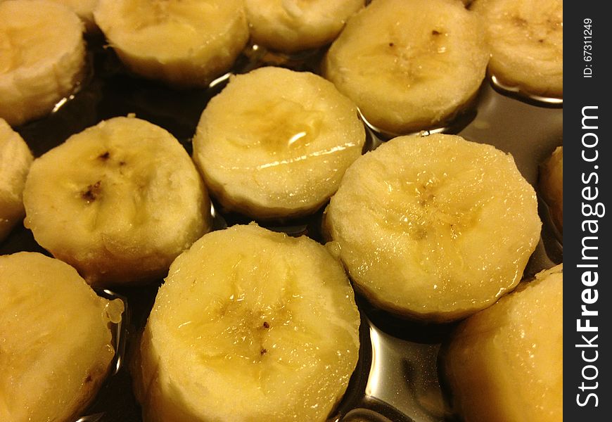 Sliced Bananas on Frying Pan in Oil Ready to be Fried. Sliced Bananas on Frying Pan in Oil Ready to be Fried.