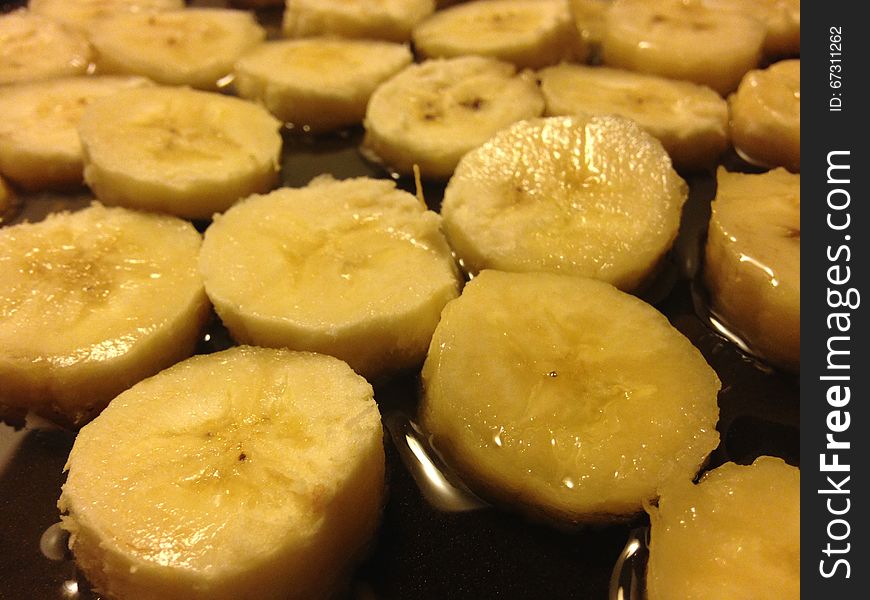 Sliced Bananas on Frying Pan in Oil Ready to be Fried. Sliced Bananas on Frying Pan in Oil Ready to be Fried.