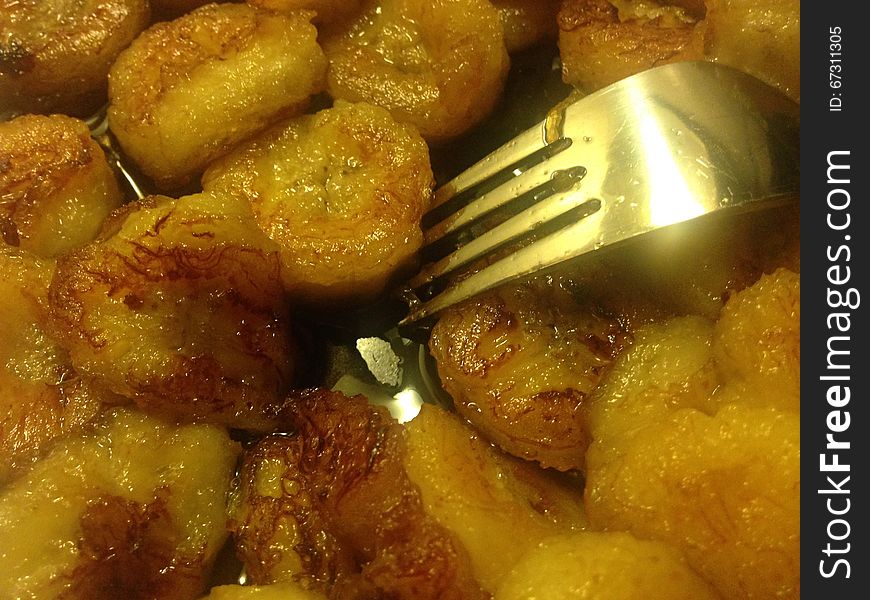 Sliced Bananas Fried In Oil With Fork On Plate.