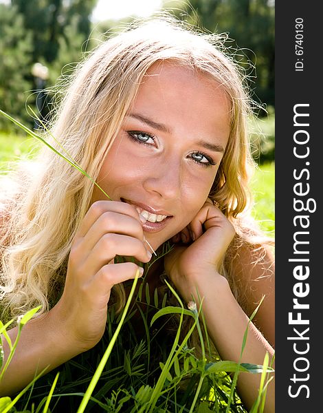 Young blond woman smiling in a park. Young blond woman smiling in a park