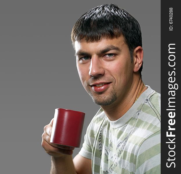 Young handsome brunet holding a cup of something, smiling. Young handsome brunet holding a cup of something, smiling