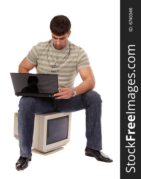 Contemporary young guy sitting on an old-fashioned computer and working with laptop, isolated on white background. Contemporary young guy sitting on an old-fashioned computer and working with laptop, isolated on white background