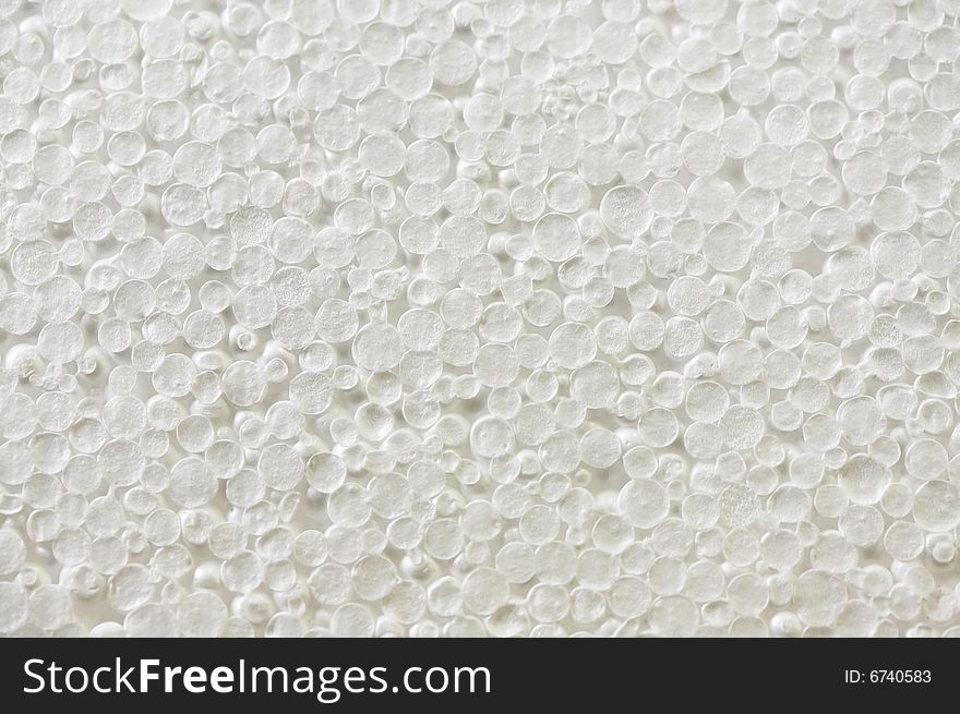 The textures of a surface of a white plate of polyfoam. The textures of a surface of a white plate of polyfoam