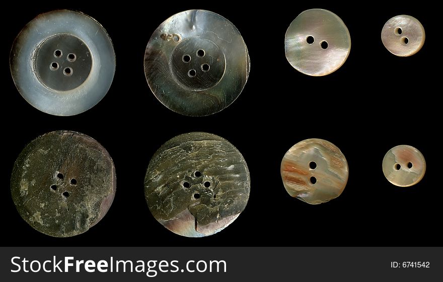 Old nacreous sewing buttons on a black background