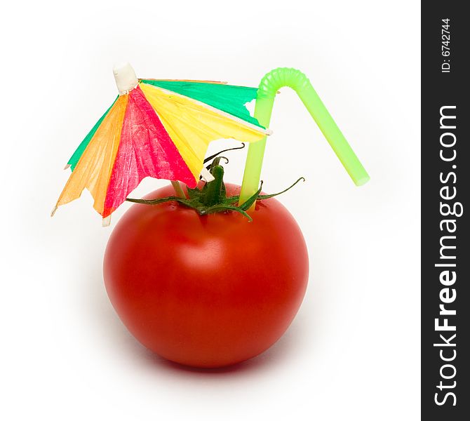 Tomato with cocktail umbrella and straw for a cocktail. Tomato with cocktail umbrella and straw for a cocktail.