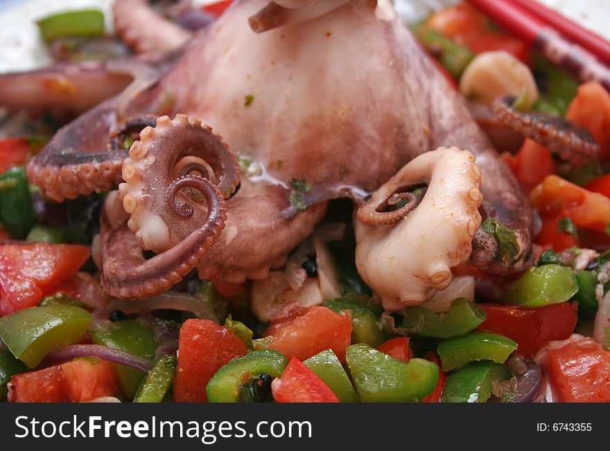 A grilled octopus with different kind of vegetables