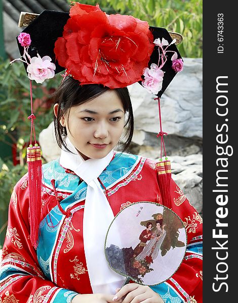 Portrait of a beautiful girl in Chinese ancient dress. 
Chinese on the fan is meant and missed. Portrait of a beautiful girl in Chinese ancient dress. 
Chinese on the fan is meant and missed.