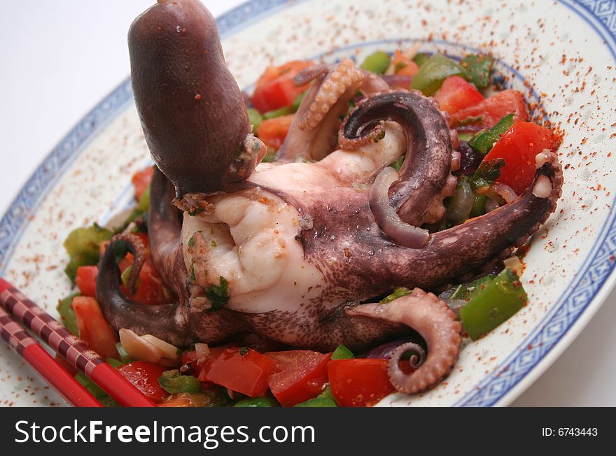 A grilled octopus with different kind of vegetables
