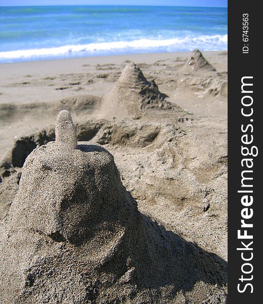 Sandcastle on the beach with sea on the background