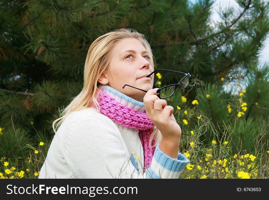 The girl sits on a lawn   in an environment of yellow colours. The girl sits on a lawn   in an environment of yellow colours