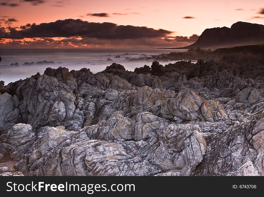 Sunset over the Bettys Bay rocky beach. Sunset over the Bettys Bay rocky beach