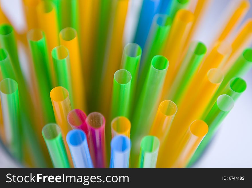 Bunch of multicolored straws on white ground