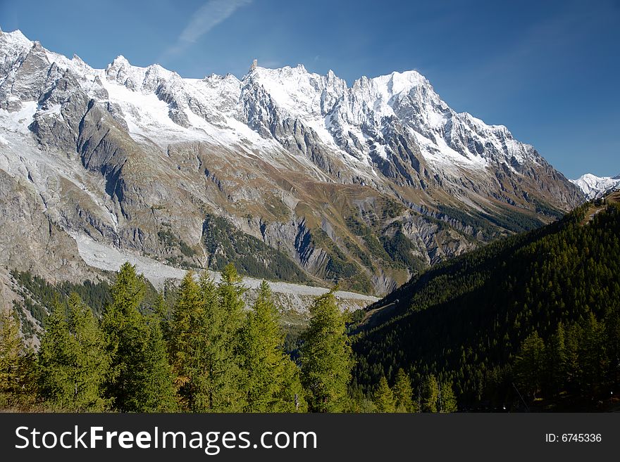 Autumn view of snowcapped peaks in an alpine valley. Gran Jourasses (Mont Blanc massif), Val Veny, Courmayeur, Italy. Autumn view of snowcapped peaks in an alpine valley. Gran Jourasses (Mont Blanc massif), Val Veny, Courmayeur, Italy.