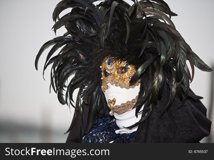 A mask with black feathers at the Venice Carnival. A mask with black feathers at the Venice Carnival