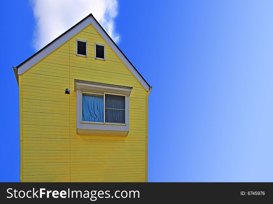 Yellow house against a bright blue sky.