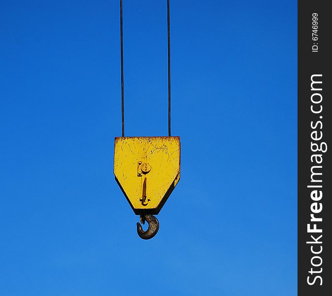 Yellow crane hook isolated on blue sky