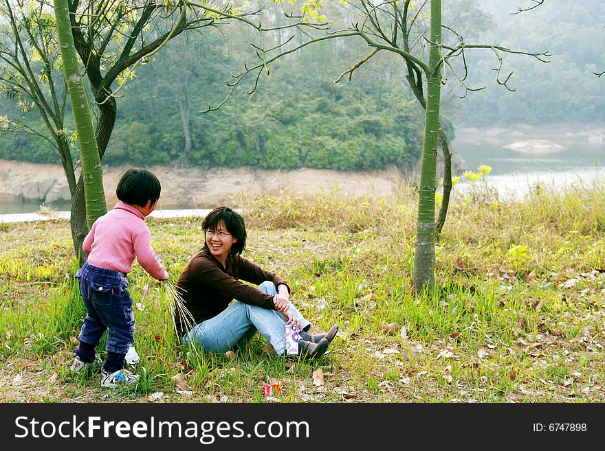 Beautiful pair of mother and daughter outside in the grass。