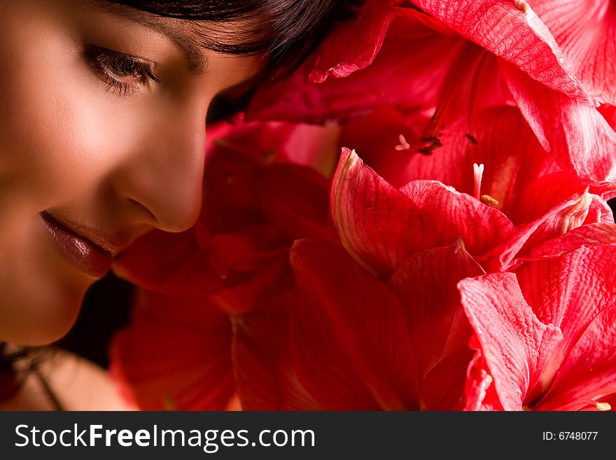 Nice smiling girl is smiling and red flowers. Nice smiling girl is smiling and red flowers