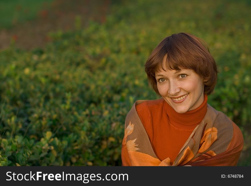 Young woman against a grass background.