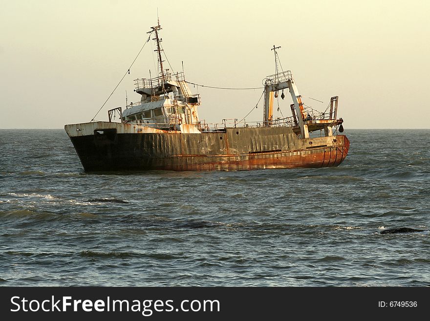 Shipwreck at sunset in ocean