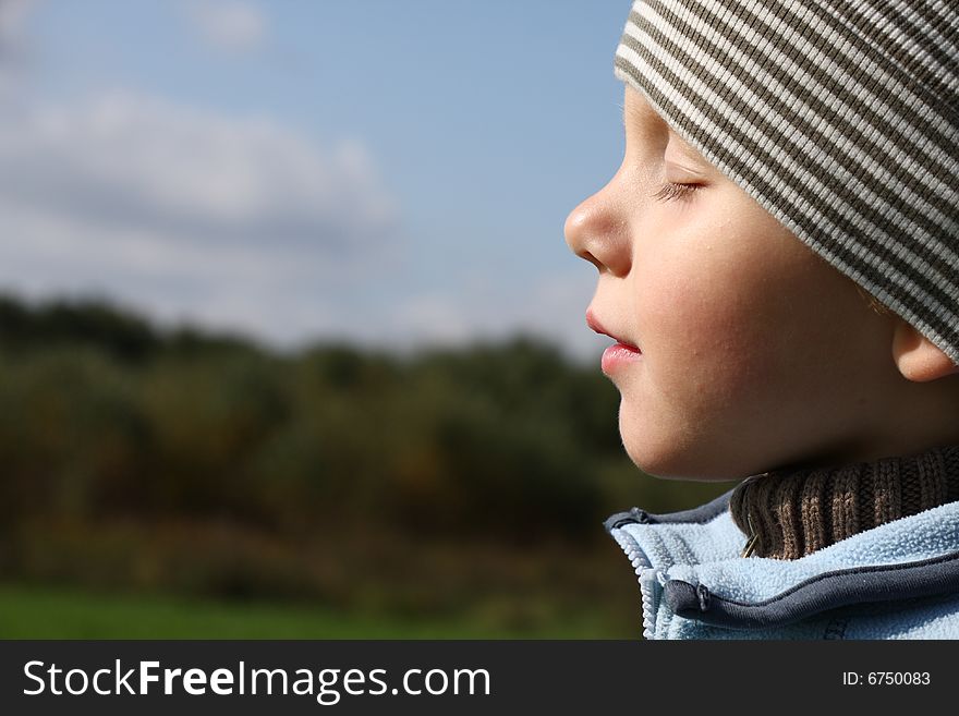 Young boy enjoying sun in autumn