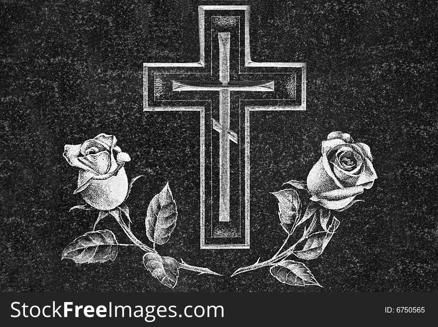 Cross and roses on a dark granite gravestone