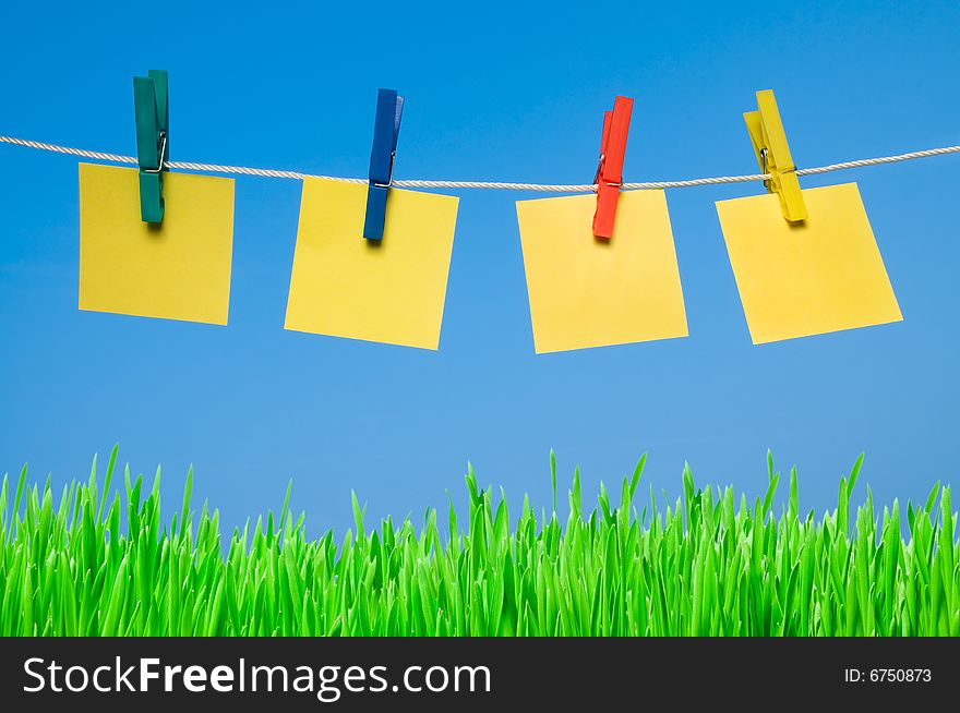 Four different post it hanging out with colorful pegs in a sunny day. Write it on whatever you want!. Four different post it hanging out with colorful pegs in a sunny day. Write it on whatever you want!