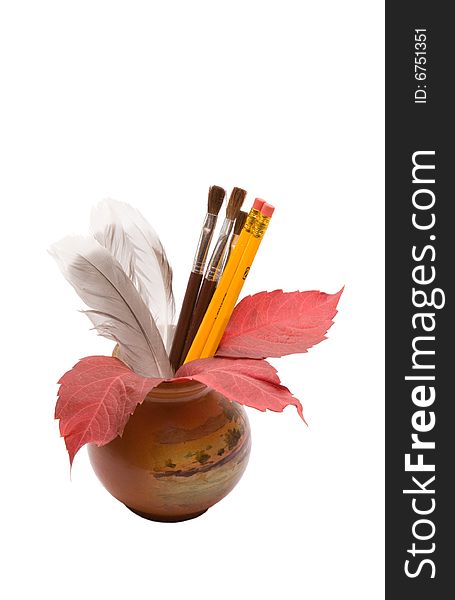 Vase with feathers,pencils and leafs