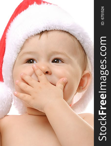 Cute toddler in Santa`s hat covers a mouth with a hand. Cute toddler in Santa`s hat covers a mouth with a hand