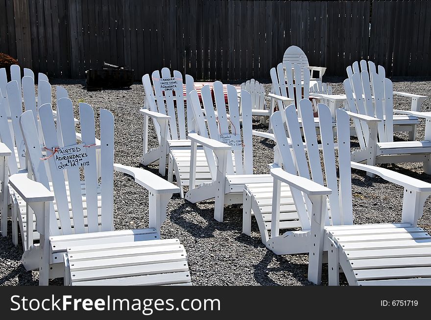 White adirondack chairs lined up for sale.