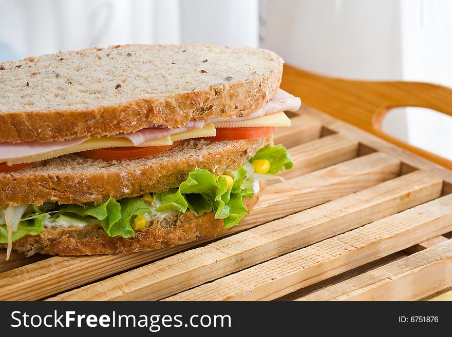 Submarine sandwich with whole grain bread on wood platter