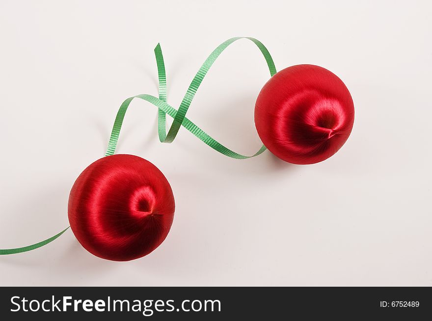 Two red Christmas Ornaments with curly green Ribbon on a white background. Two red Christmas Ornaments with curly green Ribbon on a white background