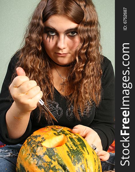 Adorned girl to Halloween c by pumpkin in the hands. Adorned girl to Halloween c by pumpkin in the hands