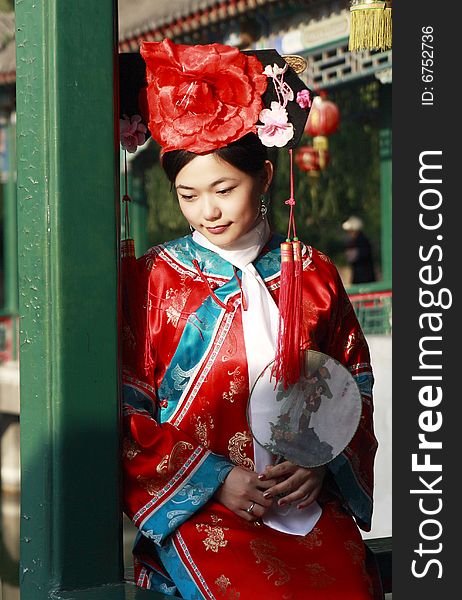 A beautiful girl in Chinese ancient dress is in the royal garden. This is dress of Qing Dynasty of China. It is the princess' dress too. Chinese on the fan is meant and missed. A beautiful girl in Chinese ancient dress is in the royal garden. This is dress of Qing Dynasty of China. It is the princess' dress too. Chinese on the fan is meant and missed.