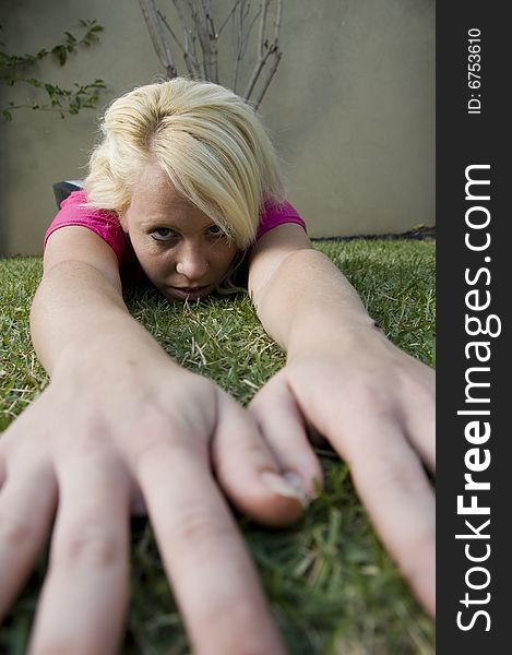 Serious american woman lying with hands on grass