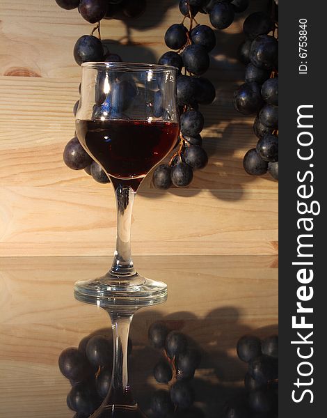 Goblet of red wine on background with grape. Goblet of red wine on background with grape